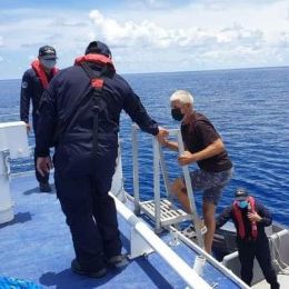 Coast watch team members help the lost skipper captain onto their boat